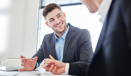Two professionals in a business meeting, smiling.